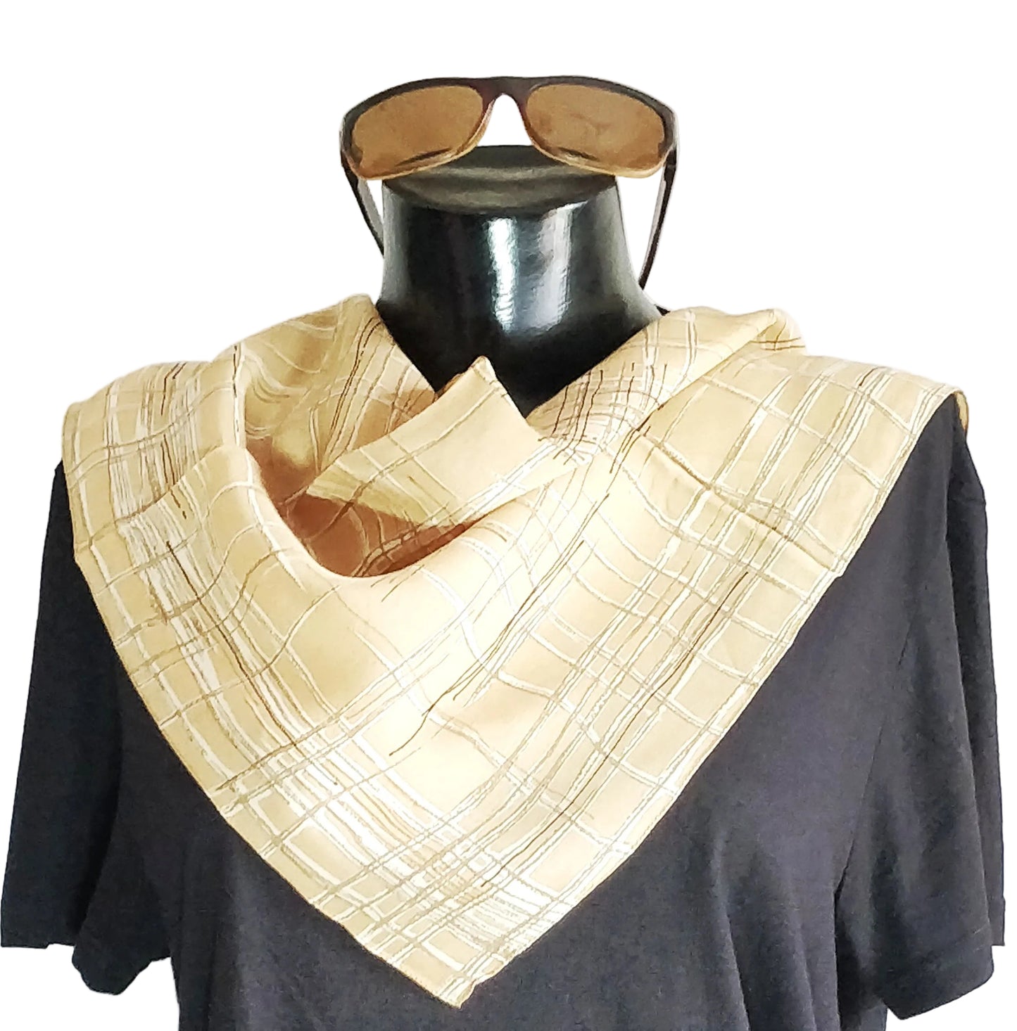A silk neckwear and bandana accessory displayed on a mannequin, featuring a geometric pattern in beige and brown tones.