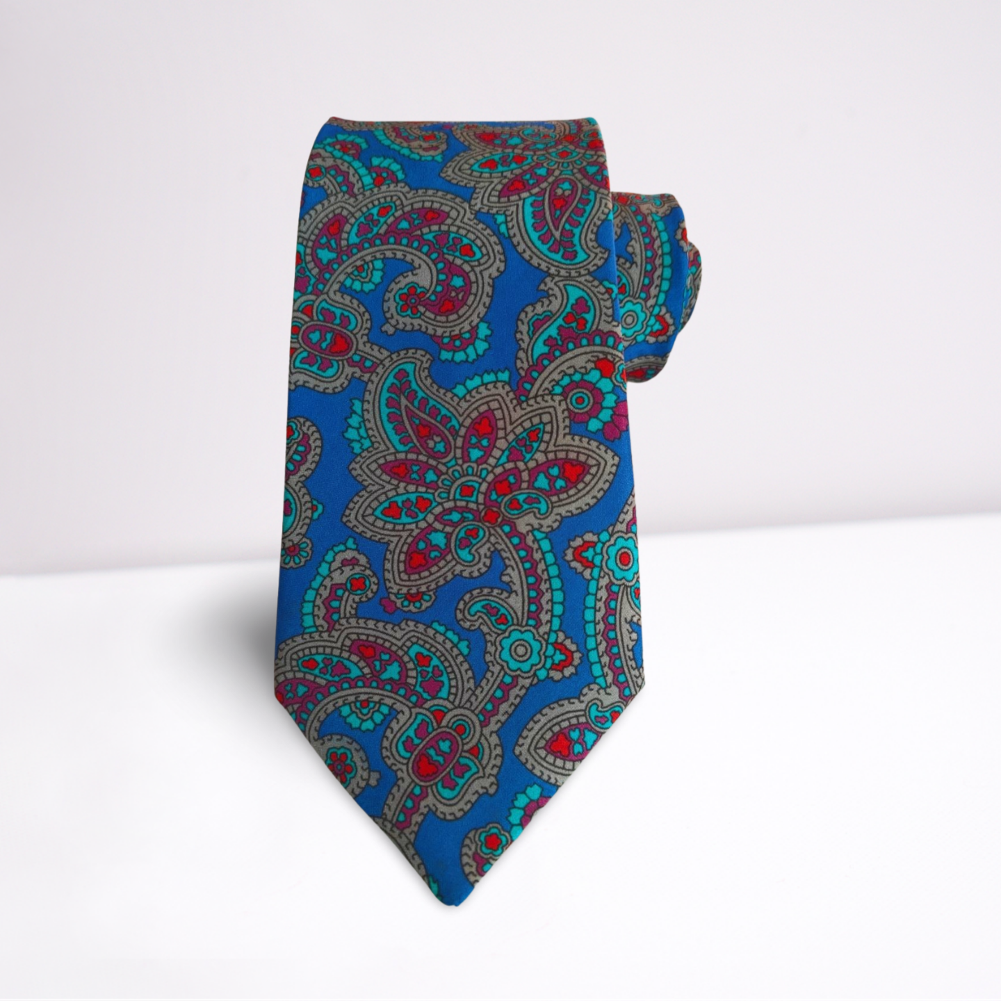 Blue paisley patterned tie on a white background
