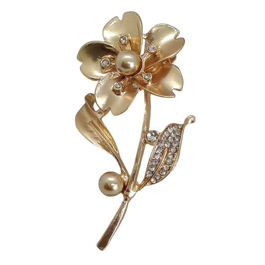A gold-tone floral brooch with pearl-like embellishments, designed as an accessory for women's attire.