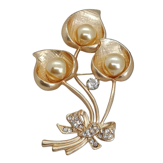A brooch with a gold-colored metal alloy base, featuring white pearls and clear rhinestones arranged in a floral pattern.